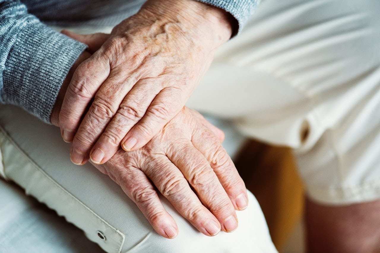 elderly couple holding hands